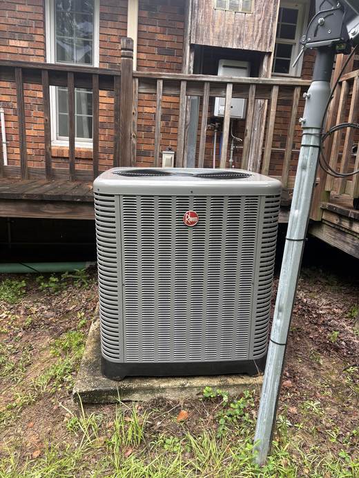 Rheem AC condenser unit installed near a wood deck in Tylertown, MS
