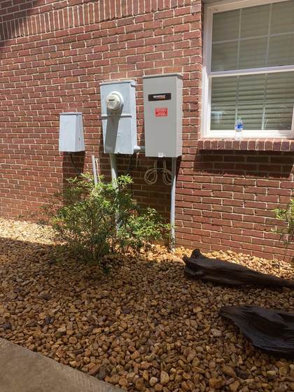 Generac emergency disconnect and electrical meter installed on brick wall
