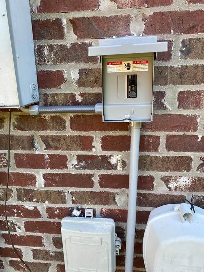 Electrical meter and disconnect panel installed on a brick home