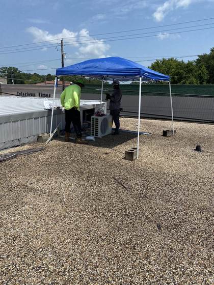 JAE technicians installing a rooftop AC unit in Tylertown, MS